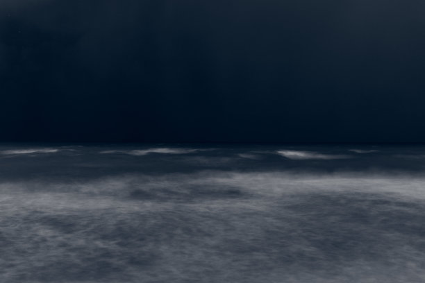 模糊的散焦蓝色海浪在深夜，美丽模糊的风暴潮海景在蓝色黄昏图片下载