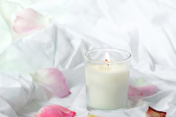 豪华舒适的蜡烛在罐子与白色织物背景，干芦苇波西米亚风格。燃烧香薰蜡烛，手工蜡烛，高质量的照片，情人节浪漫的概念图片下载