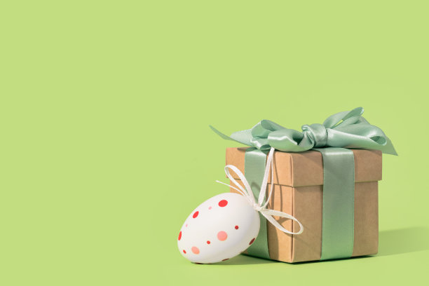 复活节彩绘彩蛋和绿色背景的礼盒。图片下载