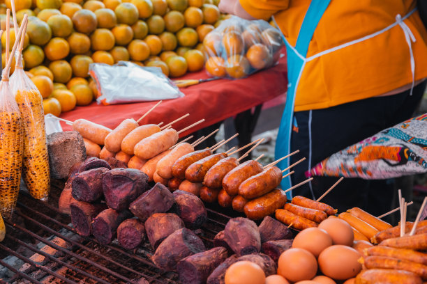 在泰国北部的Doi Kio Lom，一名街头小吃摊和水果小贩正在烤制泰式香肠和蔬菜。图片下载