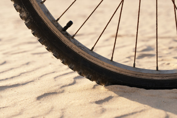 沙漠中沙地上的自行车车轮特写图片下载