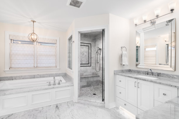 一间带浴缸、大理石台面和步入式淋浴间的白色浴室。图片下载