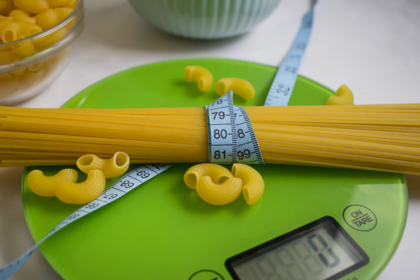 干意大利面，厨房的天平，浅色背景图片下载