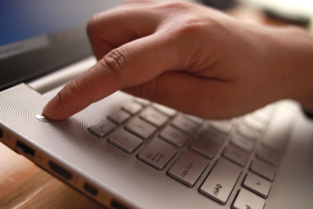 人用手按笔记本电脑的电源按钮图片下载