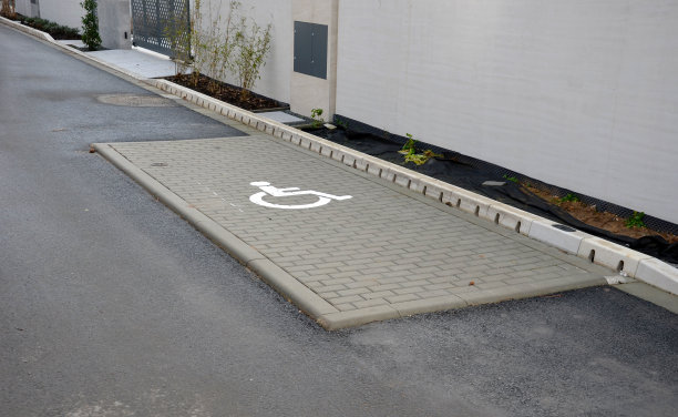 隐藏在柏油路边缘的排水系统隐藏在穿孔混凝土灰色路边的排水系统。水沿着整条路的长度排入下水道，通过洞、草扎图片下载