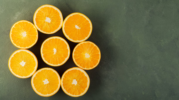 把橙子切成花的形状。绿色背景上有多汁的橙子。前视图。本空间图片下载