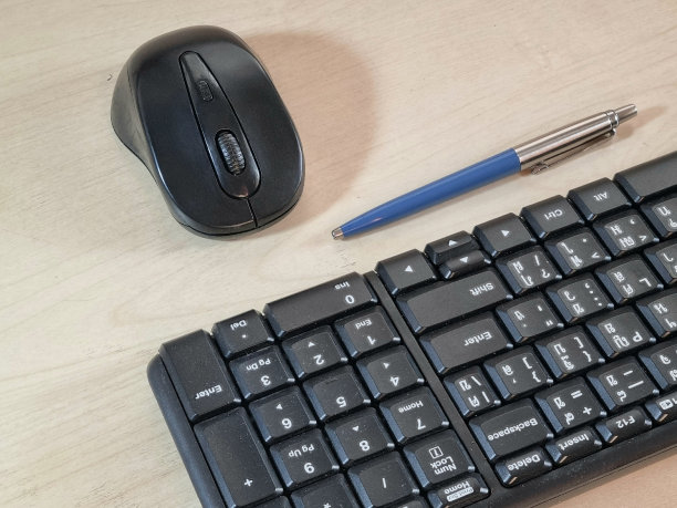 电脑键盘，鼠标和笔在办公桌上图片下载