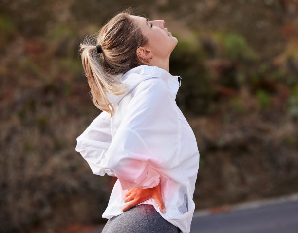 女性，背部疼痛和运动，健身损伤和肌肉疼痛，炎症时训练户外运动。跑步者、运动员与健康、跑步时的疼痛与背痛、道路上的有氧运动与健康。图片下载