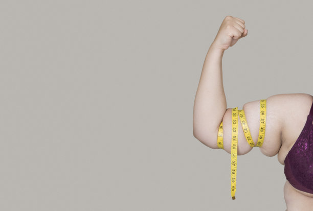 肥胖的年轻女子显示手臂包裹的措施图片下载