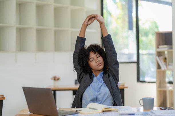 坐在舒适的办公椅上放松一下，伸展一下身体。图片下载