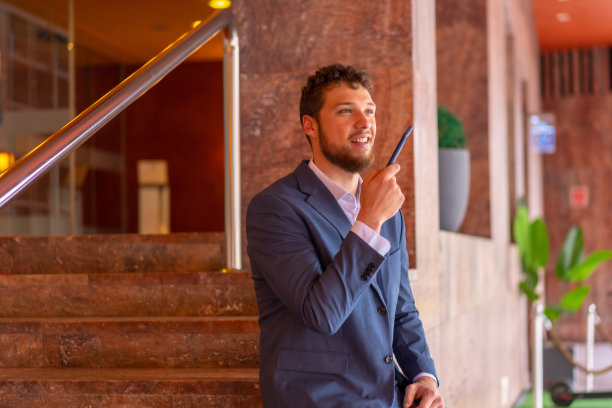 商人或金融人员在一个活动的酒店门口用电话远程工作图片下载