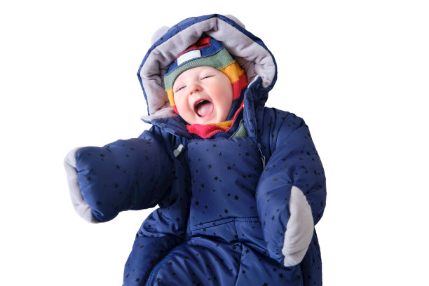 一个快乐的孩子穿着暖和的冬装，孤零零地躺在白色的背景上。孩子九个月大图片下载