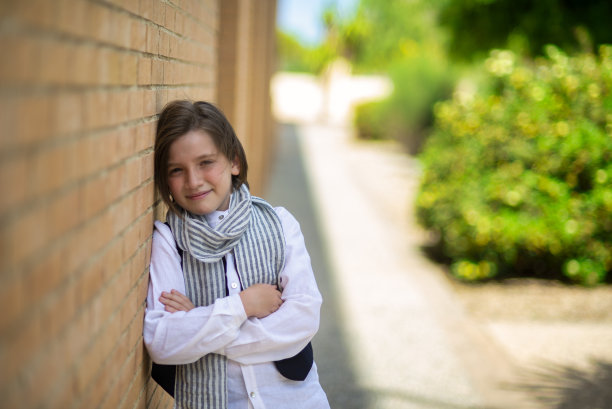 穿着优雅的黑发男孩，9岁，姿势同情。图片下载
