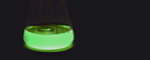 在黑暗中发光的实验室烧瓶。炼金术魔法药水。绿色有毒毒药。装有绿色荧光药物的玻璃烧杯图片下载