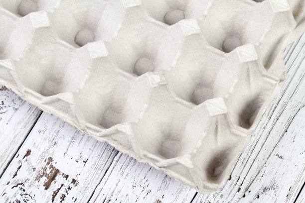 特写的一部分空鸡蛋托盘上的木制背景图片下载