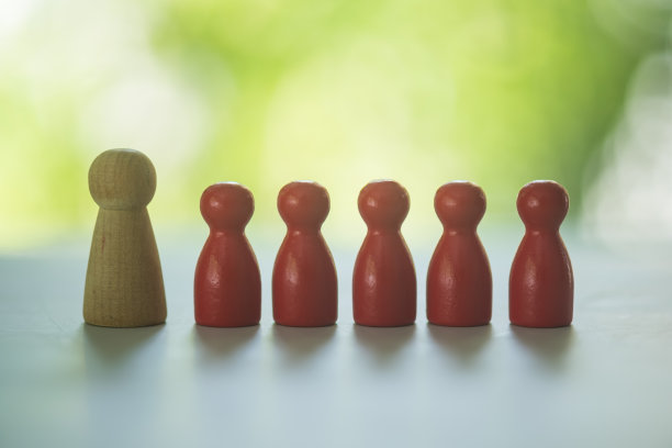 一个大的木制模型旁边的木制小红色模型人在自然背景。图片下载