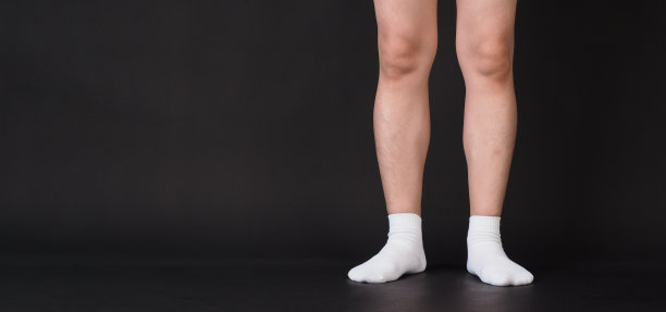 亚洲男性的腿穿白色袜子是孤立的黑色背景图片下载