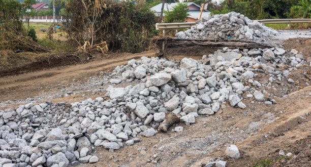 大大小小的花岗岩碎片堆积在干旱的运河里。图片下载