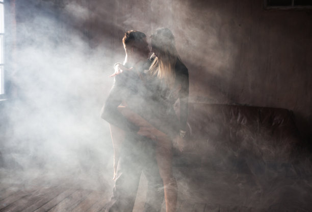 一对两名专业交际舞演员在阁楼工作室跳舞。优美的艺术表演，烟雾缭绕。运动生活理念。激情与情感之舞。图片下载