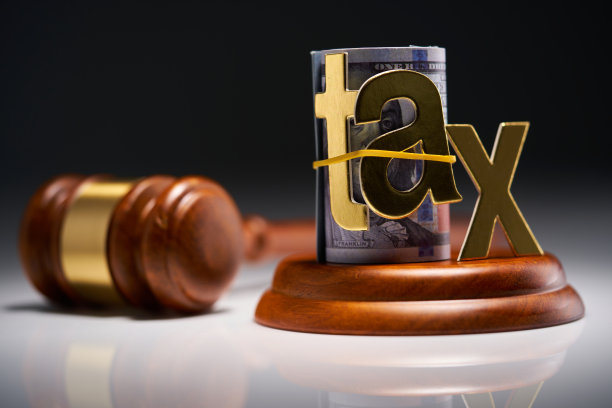 灰色背景下的法官槌与卷起的美元，以及“税”字图片下载