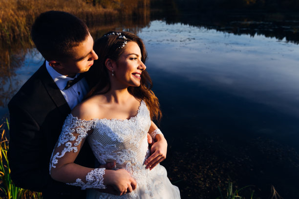 新婚夫妇在湖边拥抱的特写镜头。beautifu图片下载