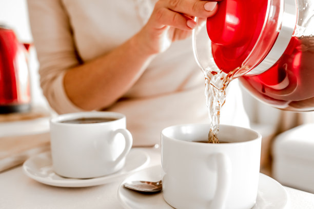 在厨房用茶壶和杯子沏茶图片下载