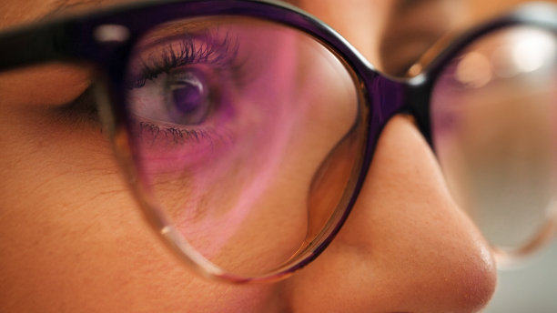 晚上工作的女人看着显示器，眼镜上的反光。图片下载