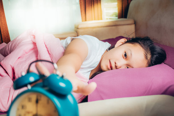 漂亮的女孩昏昏欲睡。女孩想关掉警报。清晨醒来。学生们很早就起床去上学。图片下载