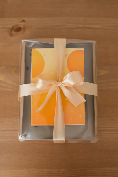 蛋糕明信片在一个用缎带装饰的牛皮纸盒子上的桌子，俯视图图片下载