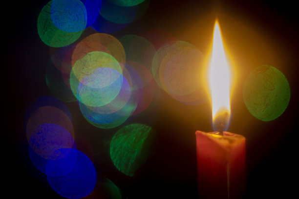 燃烧的蜡烛在抽象的颜色散景背景图片下载