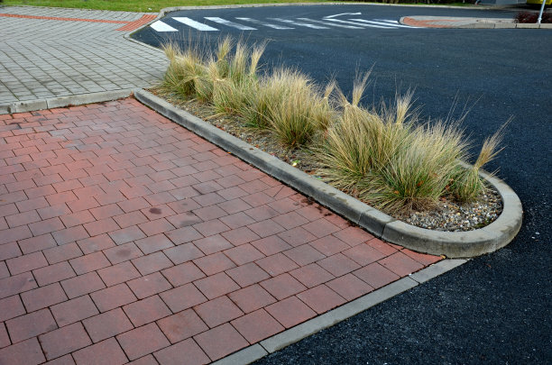 干草的叶子在风中卷曲，看起来像头发。草坪和几棵树。花坛与钣金路边和轻大理石，石灰石覆盖碎石。现代公园在秋天，红瓦图片下载