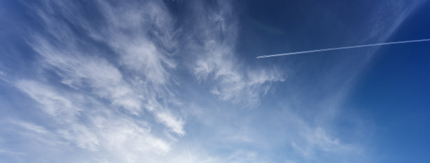 飞机在蓝天上留下一道白色的条纹。美丽宁静的风景抽象背景图片下载