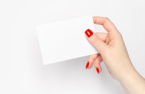 近看，女人红指甲的手拿着空白的白纸。图片下载