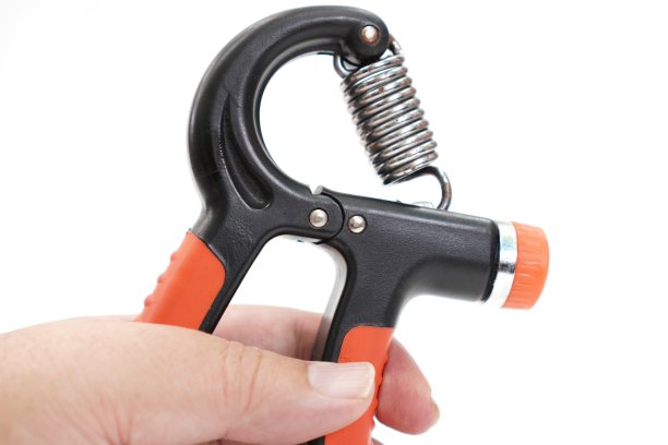 图像显示一个手指肌肉训练设备与可调节的重量在白色背景。图片下载