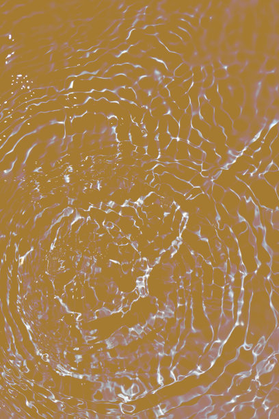 离焦模糊透明金色清晰平静的水面纹理与飞溅和气泡。潮流抽象的自然背景。水波在阳光下带有焦散。黄水闪烁图片下载