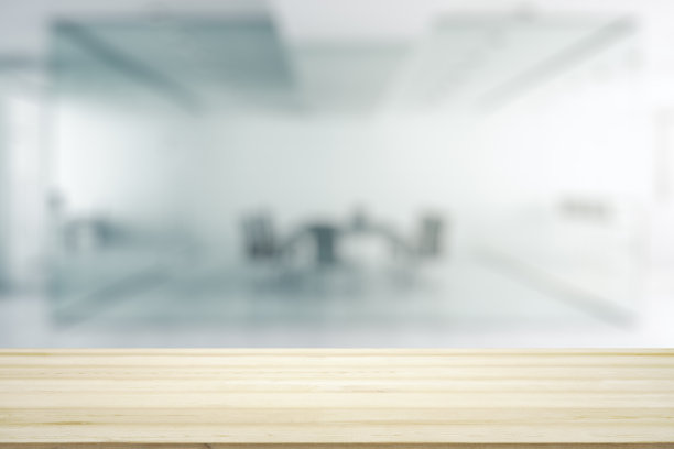 空荡荡的木制办公桌，背景是阳光明媚的会议室，模拟图片下载