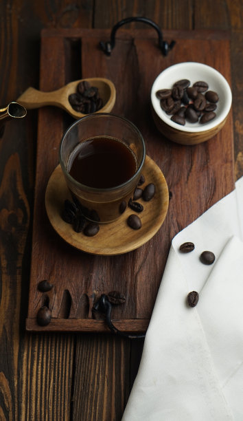 木桌上放着一杯黑咖啡和咖啡豆。图片下载