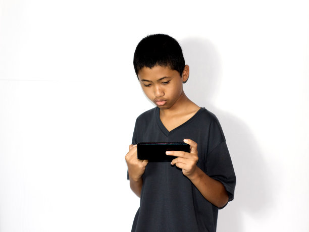 男孩使用孤立的白色背景手机图片下载