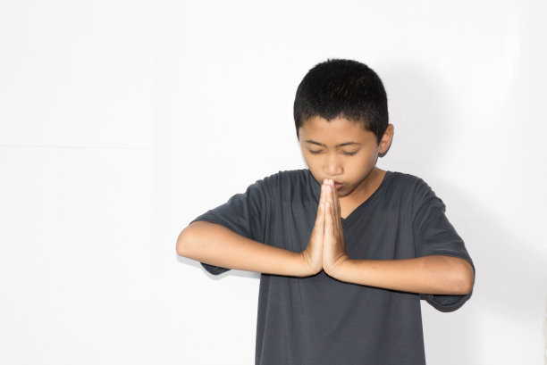 亚洲男孩在孤立的白色背景上祈祷图片下载