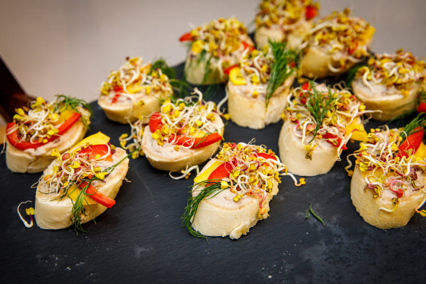 一套漂亮的小三明治放在黑色的石盘上。自助餐桌上。图片下载