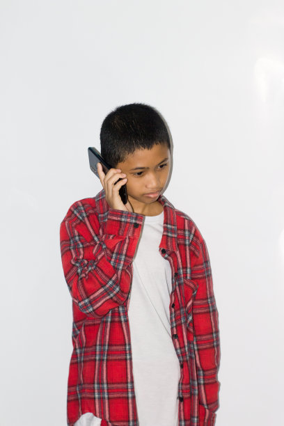 小男孩使用孤立的白色背景手机图片下载