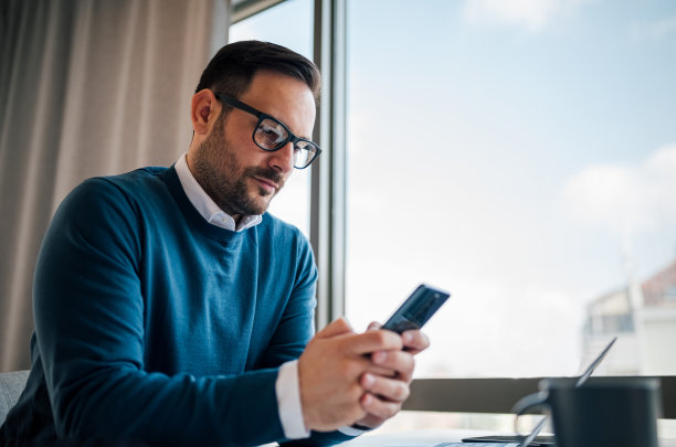 有思想的年轻成年企业主，通过电话联系他的客户。图片下载