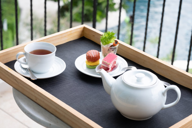 下午茶，英式传统饮品，甜点，白盘马卡龙和蛋糕。图片下载