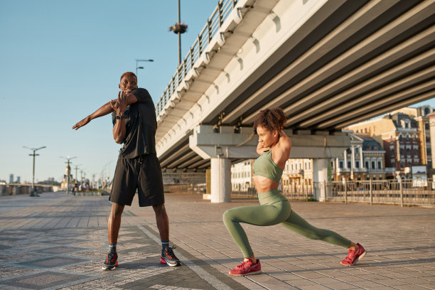 微笑的黑色运动夫妇伸展在市区图片下载