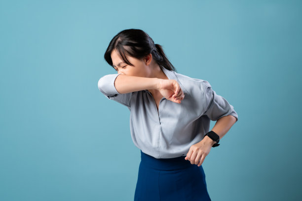 亚洲妇女发烧，流鼻涕，咳嗽和打喷嚏，蓝色背景隔离。图片下载