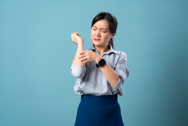 亚洲妇女遭受刺激瘙痒她的皮肤孤立站在蓝色背景。图片下载