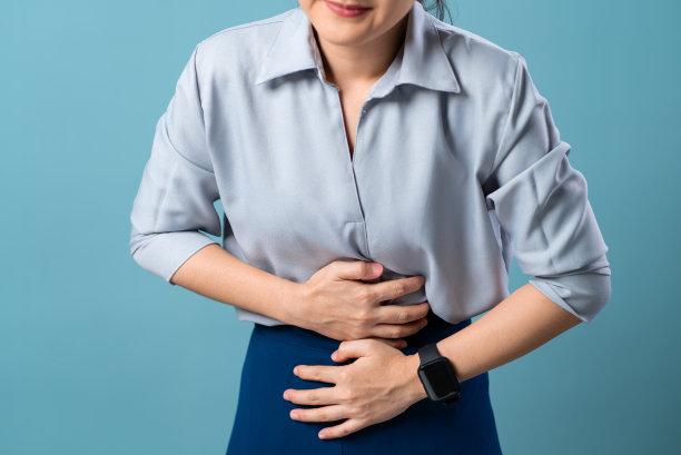 特写镜头，一个女人胃疼，孤立地站在蓝色背景上。图片下载