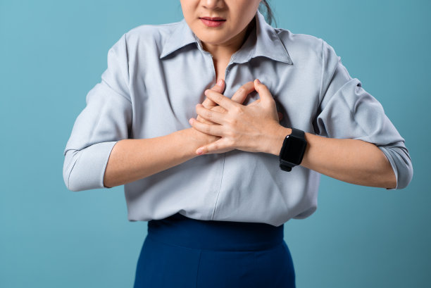 特写镜头的妇女有严重的胸痛孤立地站在蓝色背景。图片下载