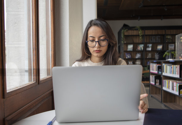 年轻漂亮的女人用她的电脑工作图片下载