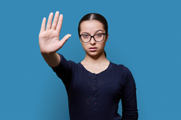 严肃自信的少女看着相机，用手掌做停止的手势图片下载